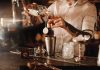 Here is a picture of a bartender pouring a drink at the bar.