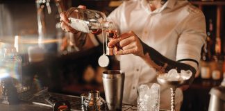 Here is a picture of a bartender pouring a drink at the bar.